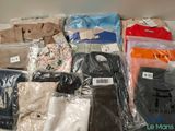 de nombreux types de chemises et de pantalons posés sur la table