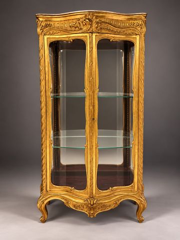 Vitrine en bois doré galbée et vitrée trois faces ouvrant à deux 
