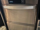 a silver dishwasher sitting on a tiled floor in a kitchen