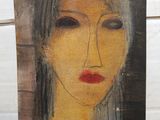an image of a painting of a woman ' s face on a piece of wood
