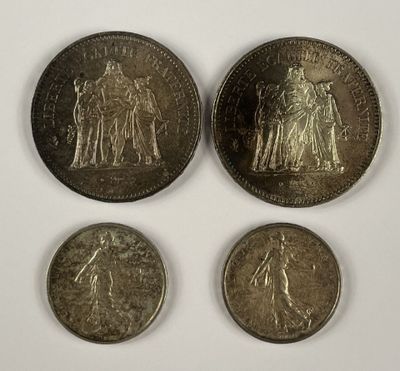 quatre pièces de monnaie britanniques différentes empilées les unes sur les autres sur une surface blanche
