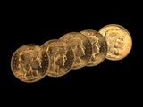un gros plan sur un tas de pièces d'or sur fond noir