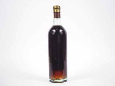une bouteille d'alcool posée sur une surface blanche