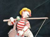 a figurine of a man holding a stick and a bag