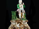 a figurine of a man sitting on top of a tree stump