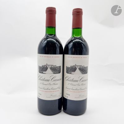 deux bouteilles de vin rouge posées l'une à côté de l'autre sur une surface blanche