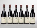 six bouteilles de vin rouge sont alignées sur une table