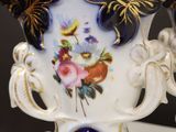 a white vase with a blue and gold decoration on it