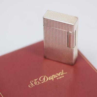 a silver lighter sitting on top of a red book