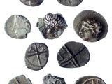several silver coins with designs on them on a white surface