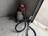 une paire de ciseaux posée par terre à côté d'une porte