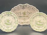three green and white plates with birds on them on a table