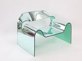 a glass chair that is sitting on a white surface