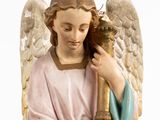 a statue of an angel holding a candle in his hands