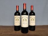 three bottles of wine sitting on top of a wooden table