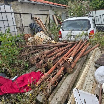 une voiture blanche garée à côté d'un tas de bois