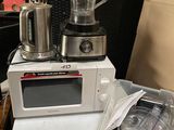 a blender sitting on top of a microwave next to a container
