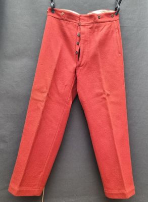 un pantalon rouge suspendu à un cintre accroché au mur