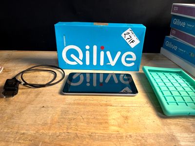 une tablette posée sur une table à côté d'une boîte