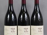 trois bouteilles de vin sont alignées sur une table
