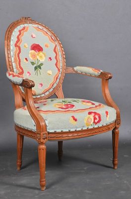 an old chair with a floral upholstered back and wooden legs