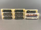 quatre trains miniatures sont alignés dans des boîtes en plastique posées sur une table