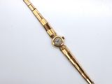 a gold wrist watch with a white face and a gold band