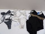 lot of baby clothes and accessories for sale on a table
