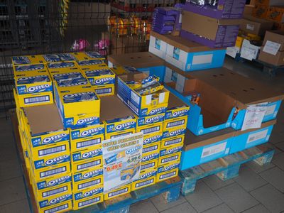 Plusieurs cartons de dentifrice sont empilés sur une palette dans un magasin