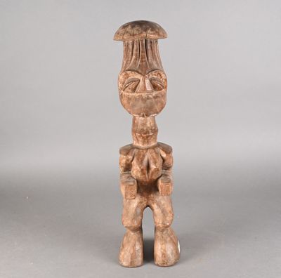 une vieille statue en bois représentant une femme coiffée d'un chapeau