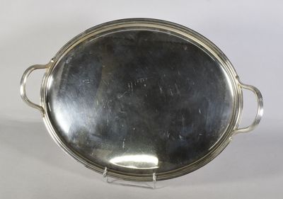 une assiette en argent ancienne avec des poignées et des poignées sur un support