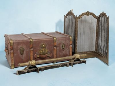 une valise marron posée à côté d'un miroir sur un fond bleu