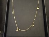 une boîte noire sur laquelle sont accrochés un collier en or et deux breloques
