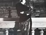 black and white photograph of a woman in a sequinned dress leaning on a railing