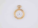 a close up of a gold pocket watch on a white surface