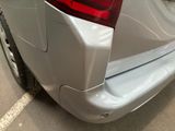 the rear end of a silver car parked in a parking lot