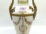 un vase blanc avec une anse dorée sur fond blanc