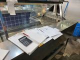 a calculator and a calculator sitting on a counter in a kitchen