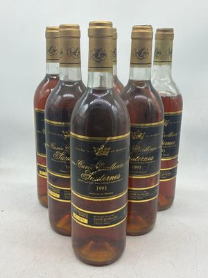 quatre bouteilles de vin sont alignées sur une surface blanche