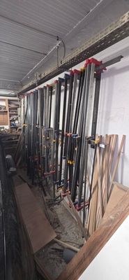 Plusieurs battes de baseball sont alignées sur une étagère dans une pièce