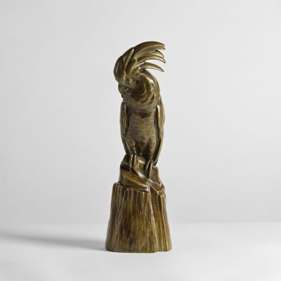 un gros plan sur la statue d'un oiseau posée sur une souche d'arbre