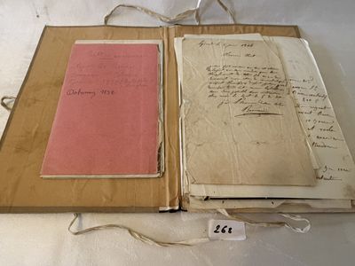 un livre ouvert posé sur une table blanche couverte d'écritures