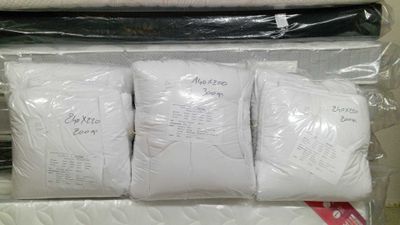 four pillows in a plastic bag on top of each other