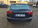 the back end of a black car parked in a parking lot