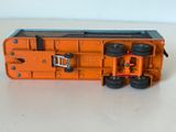 un wagon de petit train orange posé sur une table blanche