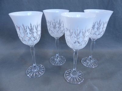 four wine glasses with etched designs on them sitting on a table