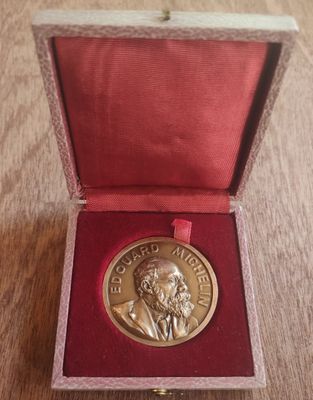un gros plan sur une médaille posée dans une boîte rouge sur une table