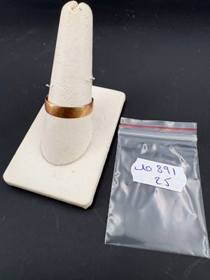 un cône blanc orné d'un anneau doré, à côté d'un sac en plastique