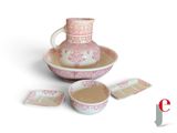 a pink and white pitcher and cups on a plate
