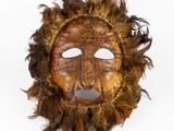 une image représentant un masque orné de plumes sur fond blanc